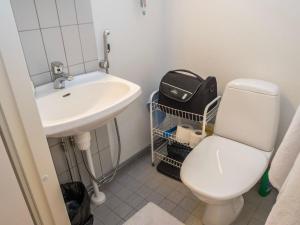 a bathroom with a white toilet and a sink at Holiday Home Karhunvartijan linna a7 by Interhome in Ruka +6 photos