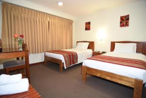 A bed or beds in a room at Hotel Prisma Cusco