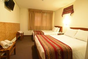A bed or beds in a room at Hotel Prisma Cusco