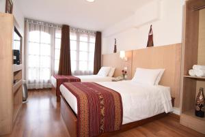 A bed or beds in a room at Hotel Prisma Cusco