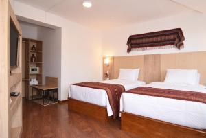 A bed or beds in a room at Hotel Prisma Cusco