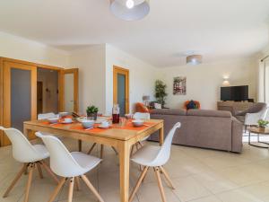 Holiday Home Vila Caravela by Interhome في Estevais: غرفة معيشة مع طاولة خشبية وكراسي بيضاء