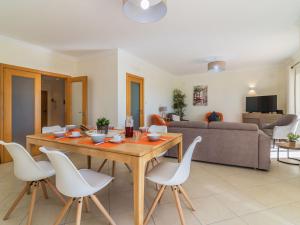 a living room with a wooden table and white chairs at Holiday Home Vila Caravela by Interhome in Estevais