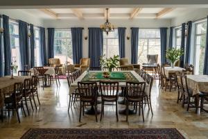 a dining room with tables and chairs and windows at Solej Rezydencja in Stronie Śląskie