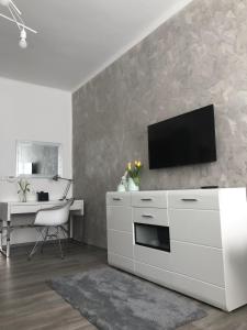una sala de estar blanca con TV en la pared en Mięta Opole, en Opole