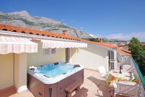 a hot tub on the balcony of a house at Apartments Ribarević in Makarska