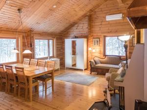 a dining room and living room in a log cabin at Holiday Home Oivangin siesta by Interhome in Nissi