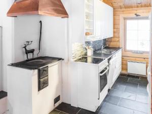 a kitchen with white cabinets and a stove at Holiday Home Oivangin siesta by Interhome in Nissi