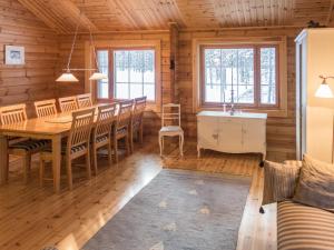 a dining room in a log cabin with a table and chairs at Holiday Home Oivangin siesta by Interhome in Nissi