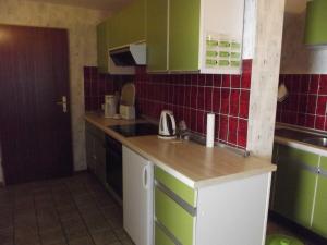a kitchen with green and white cabinets and a sink at Ferienwohnung Harms in Hitzacker