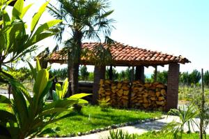 a gazebo with a pile of logs in a garden at Gugoshvili's Cellar in Kvareli