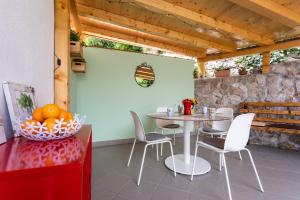 a patio with a table and chairs and a stone wall at Apartments Ana Baska in Baška