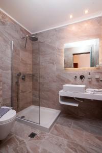 a bathroom with a shower and a toilet and a sink at Hotel Diamond in Limenaria