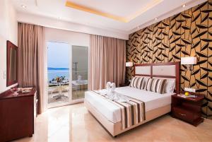 a bedroom with a bed and a balcony with the ocean at Hotel Diamond in Limenaria