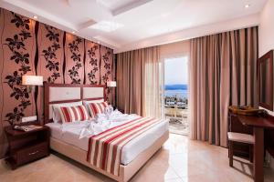 a bedroom with a bed and a desk and a window at Hotel Diamond in Limenaria