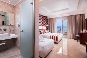 a hotel room with a bed and a bathroom at Hotel Diamond in Limenaria