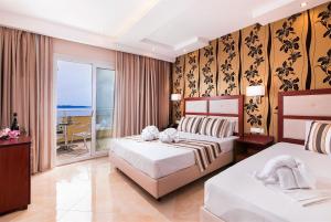 a hotel room with two beds and a balcony at Hotel Diamond in Limenaria