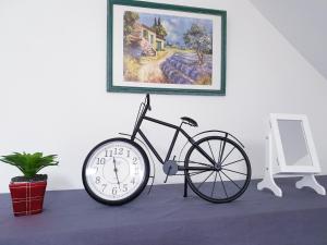 een klok zittend op een tafel naast een fiets bij Le MonMon grand T2 hyper centre ville in Fontenay-le-Comte