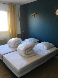 twee bedden met kussens in een slaapkamer bij Gite des 2 caps in Leulinghen-Bernes