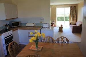 a kitchen with a table with a vase of flowers on it at Giant's Causeway Holiday Cottages in Bushmills