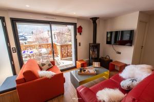 a living room with two red couches and a fireplace at Chalet Hygge Saint Lary - ressourcez-vous dans les Pyrénées in Saint-Lary-Soulan