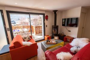 a living room with two red couches and a fireplace at Chalet Hygge Saint Lary - gîtes de standing en coeur de village des Pyrénées in Saint-Lary-Soulan