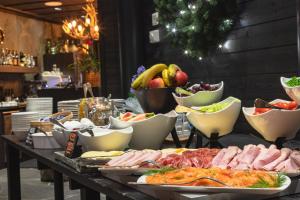 a buffet with meats and vegetables and bowls of fruit at Golden Crown - Levin Iglut in Levi +48 photos