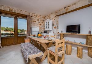 a kitchen with a wooden table and chairs and a television at Villa windmill Near Shipwreck Beach in Volímai