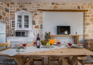 Villa windmill Near Shipwreck Beach by "elite" في Volímai: مطبخ مع طاولة خشبية مع كؤوس للنبيذ