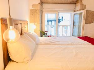 ein Schlafzimmer mit einem großen weißen Bett mit einem Fenster in der Unterkunft Enjoy the Old Town in a full renovated Duplex in A Coruña