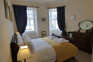 a bedroom with a bed with a dresser and two windows at 1 HAVANNAH COURT in Kelso