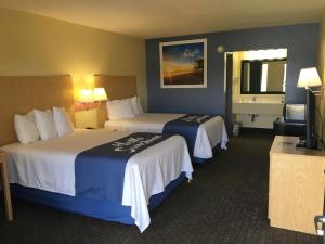 a hotel room with two beds and a television at Days Inn by Wyndham Crystal River in Crystal River