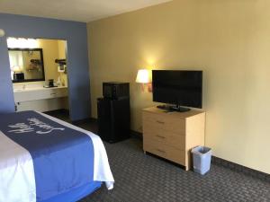 a hotel room with a bed and a flat screen tv at Days Inn by Wyndham Crystal River in Crystal River