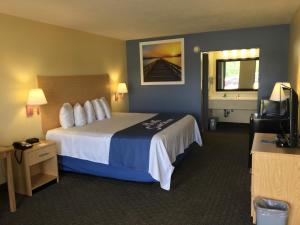 a hotel room with a large bed and a television at Days Inn by Wyndham Crystal River in Crystal River