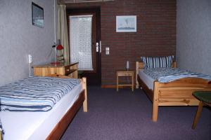 a bedroom with two beds and a brick wall at Ferienwohnung Harms in Hitzacker