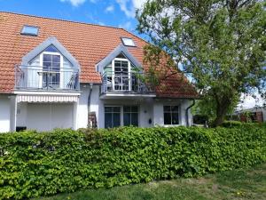een wit huis met een oranje dak bij Ferienwohnung Sonneneck in Insel Poel