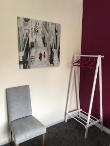 een stoel naast een muur met een foto op de muur bij The Avenues in Chelmsford