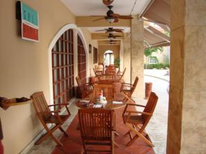 eine Reihe von Tischen und Stühlen auf einer Terrasse in der Unterkunft The Golf Suites in Punta Cana
