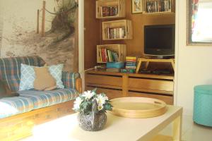 Una sala de estar con un sofá y un televisor. en Campo de Oleandros, en Lourinhã