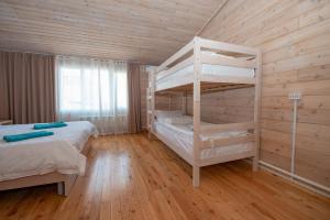 a bedroom with two bunk beds and a wooden wall at Aquamarine Resort in Akshi