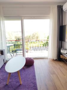 een woonkamer met een witte tafel en een groot raam bij Apartman Luka in Novigrad Istria