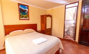 a bedroom with a bed and a mirror and a bathroom at Hotel Tamia in Huaraz