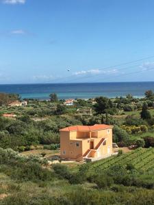 a house in a field with the ocean in the background at Rodanthy Studios IV in Katelios