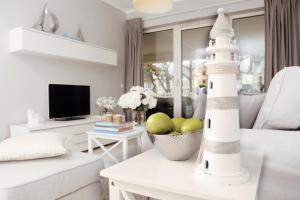 ein Wohnzimmer mit einem Leuchtturm auf einem Tisch in der Unterkunft Biały apartament z tarasem w Playa Baltis in Misdroy