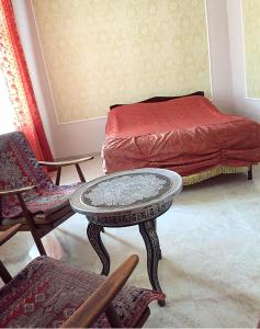 a room with a bed and a table and chairs at Hayq Guest House in Goris