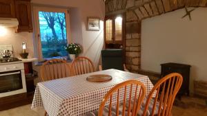 a dining room with a table and chairs and a kitchen at Bay View House in Liscannor