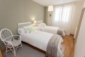 a bedroom with two beds and a chair in it at Celia in Roa