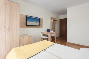 1 dormitorio con 1 cama y TV en la pared en Willa Daniela - Chłapowo en Władysławowo