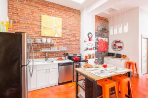 a kitchen with white cabinets and a brick wall at Condo Le 1000 - Quebec in Quebec City