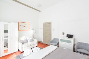 a white bedroom with a bed and two chairs at Condo Le 1000 - Quebec in Quebec City